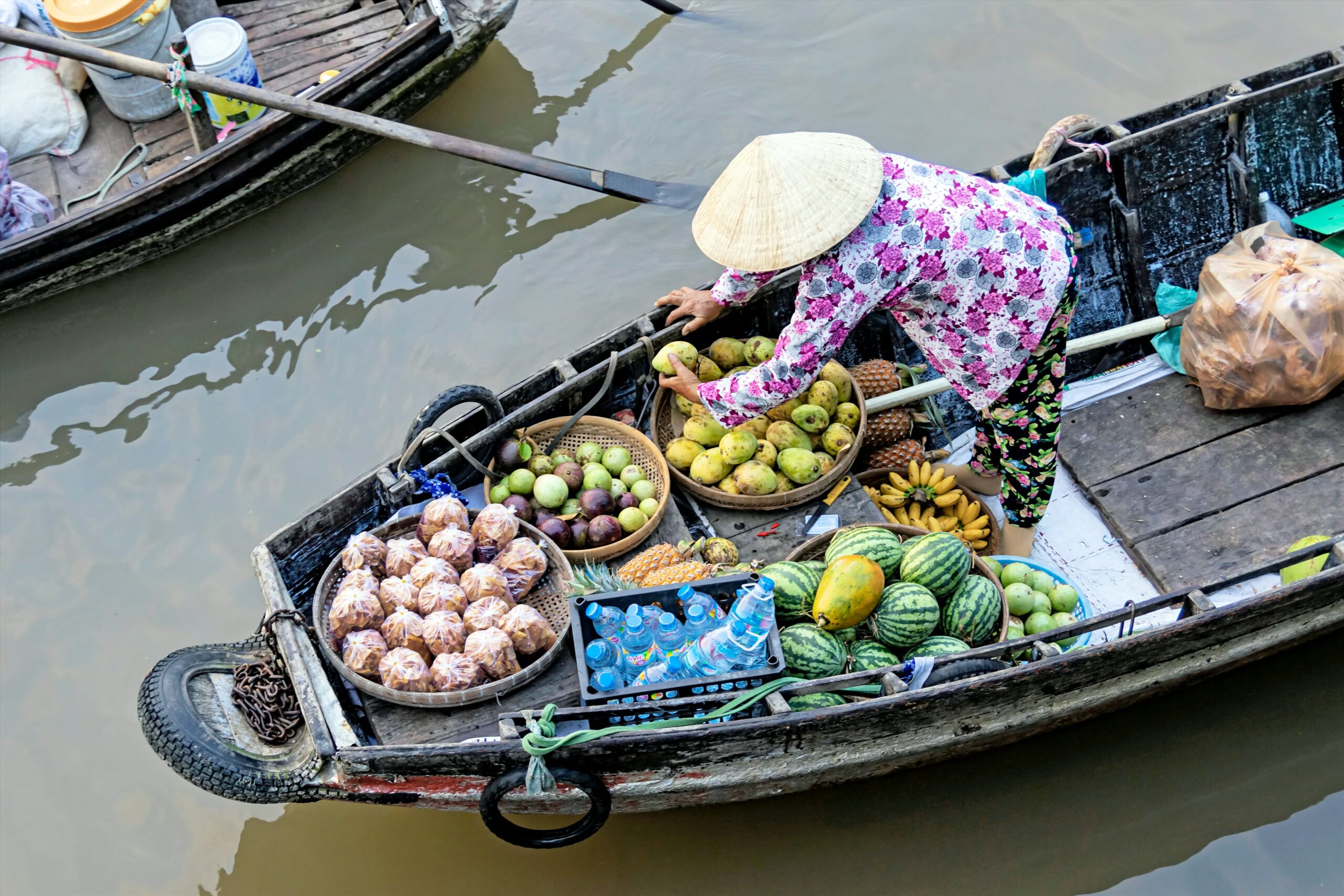 Mujer vietnamita vende aguacates y otras frutas desde su canoa en un mercado flotante del Delta del Mekong, en Vietnam.