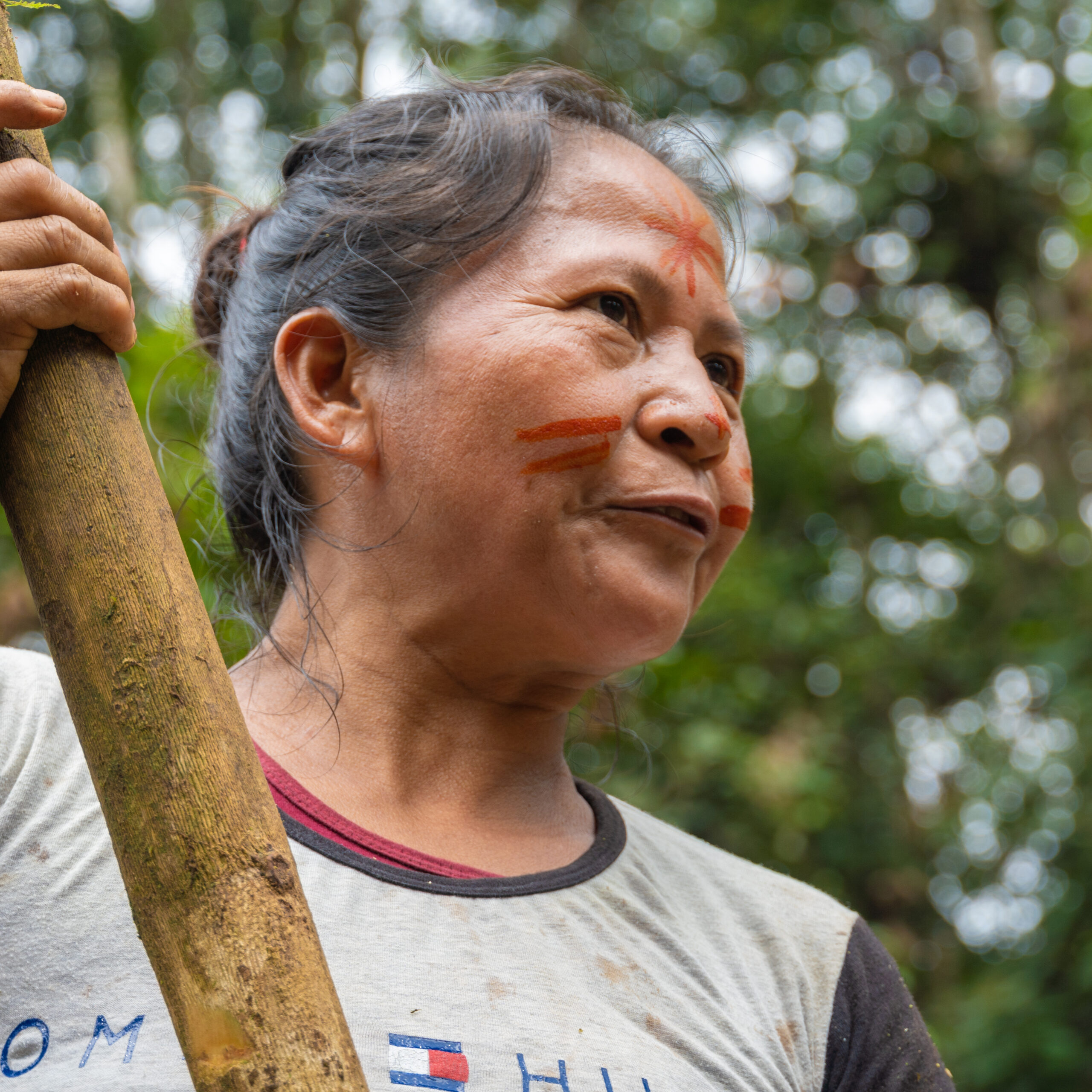 Mujer indígena kichwa pintada con achiote trabajando en la chakra en el Amazonas de Ecuador