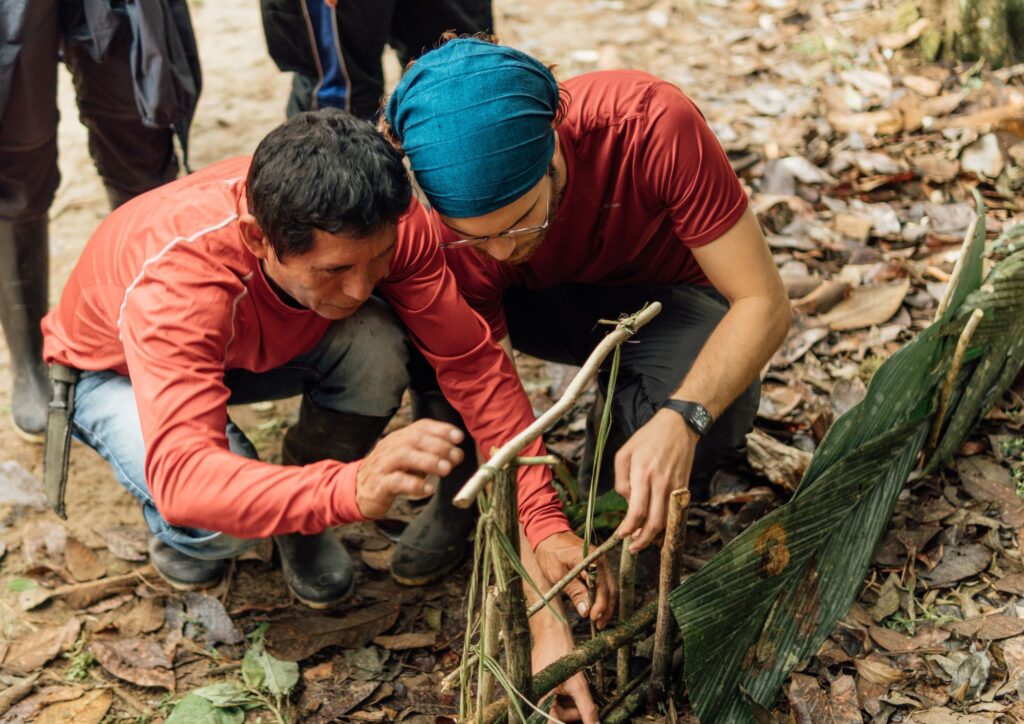 Carlos y Moisés preparan una trampa en la selva amazónica. Inmersión cultural.