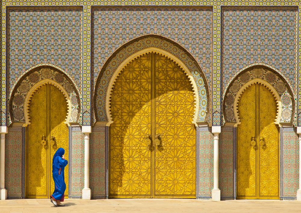 Mujer caminando por las puertas doradas de Fez. En Ramadán.